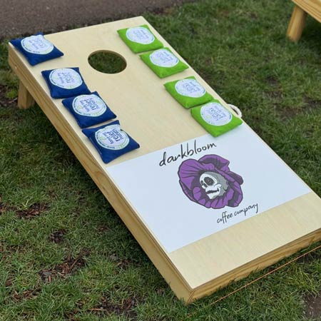 Example of a cornhole board with a sponsor logo printed on the playing surface